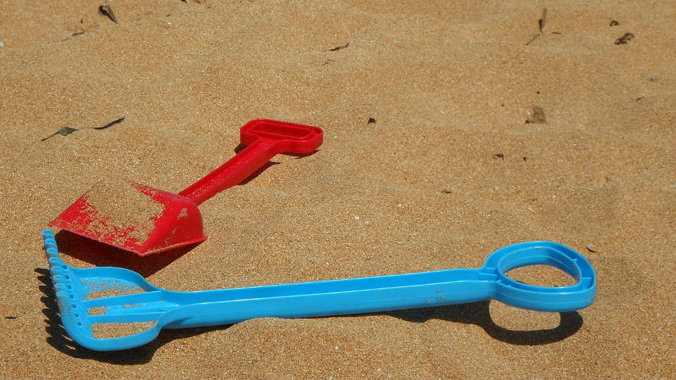 Image of children’s shovels on the beach.